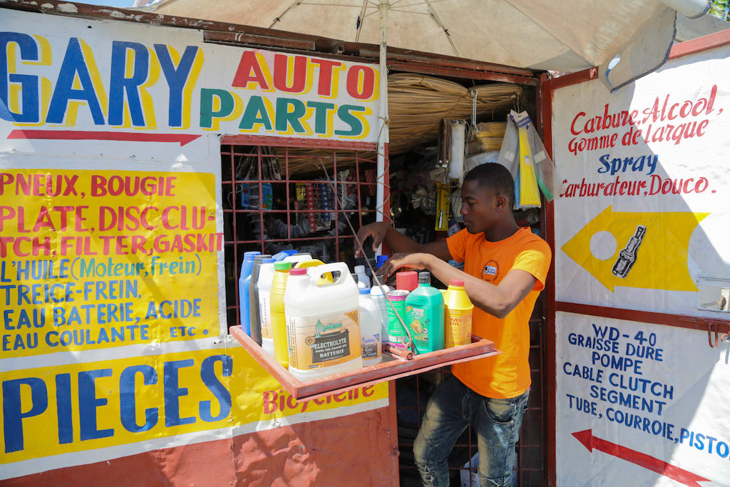 A teen boy arranges stock at his store.